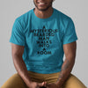 A MYSTERIOUS BEARDED MAN WALKS INTO A ROOM AQUA BLUE TSHIRT WITH BLACK MAN SMILING