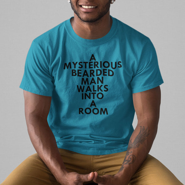 A MYSTERIOUS BEARDED MAN WALKS INTO A ROOM AQUA BLUE TSHIRT WITH BLACK MAN SMILING