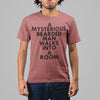 A MYSTERIOUS BEARDED MAN WALKS INTO A ROOM TSHIRT IN MAUVE MIXED ETHNICITY MAN STANDING.