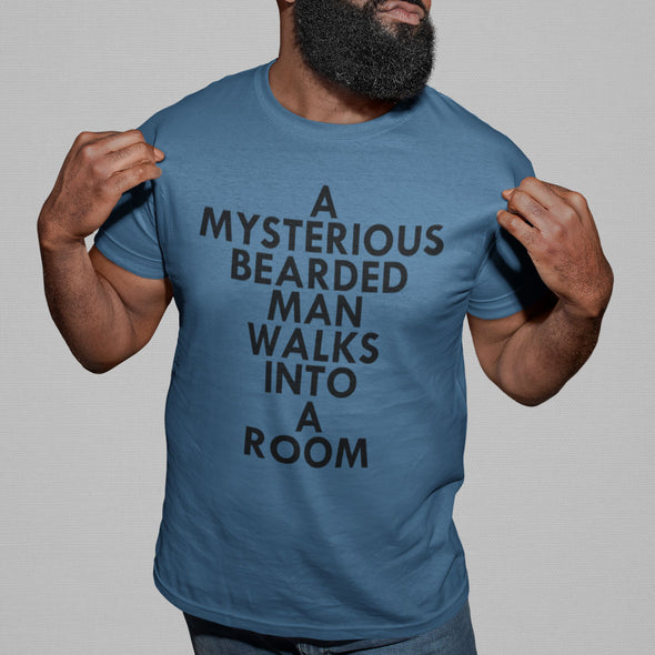 A MYSTERIOUS BEARDED MAN WALKS INTO A ROOM TSHIRT IN STEEL BLUE BLACK MAN SMILING